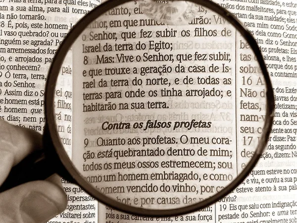 A magnifying glass over the text of a Portuguese Bible